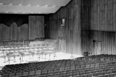 Pusta sala koncertowa filharmonii, na widowni krzesła, na estradzie pulpity