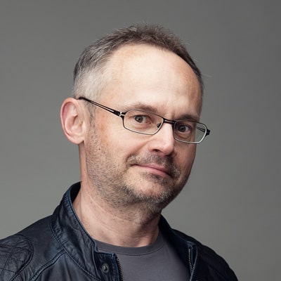 zdjęcie portretowe mężczyzny w okularach z krótkim siwym zarostem i krótkimi siwymi włosami