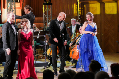 Zdjęcie 4 śpiewaków w wieczorowych strojach, śpiewających i uśmiechających się do siebie