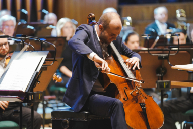 zdjęcie wiolonczelisty w młodym wieku, grającego z zaangażowaniem na wiolonczeli