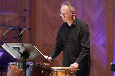 zdjęcie perkusisty w okularach w średnim wieku, grającego na werblu