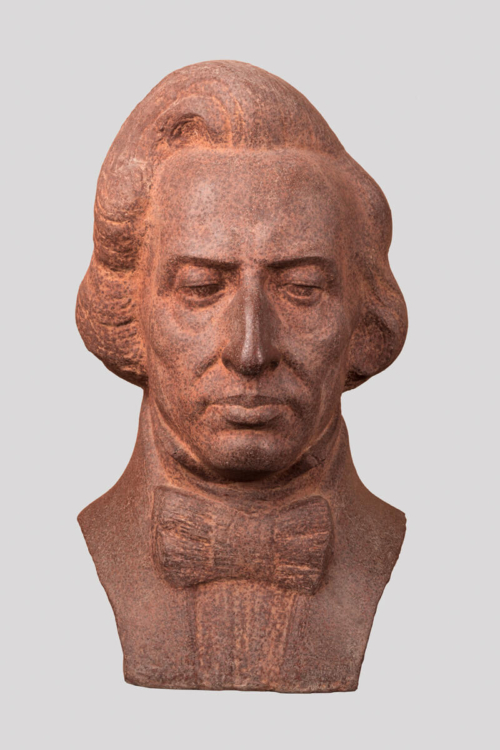 Popiersie wykonane z betonu przedstawia głowę Fryderyka Chopina z realistycznymi rysami twarzy i detalami.